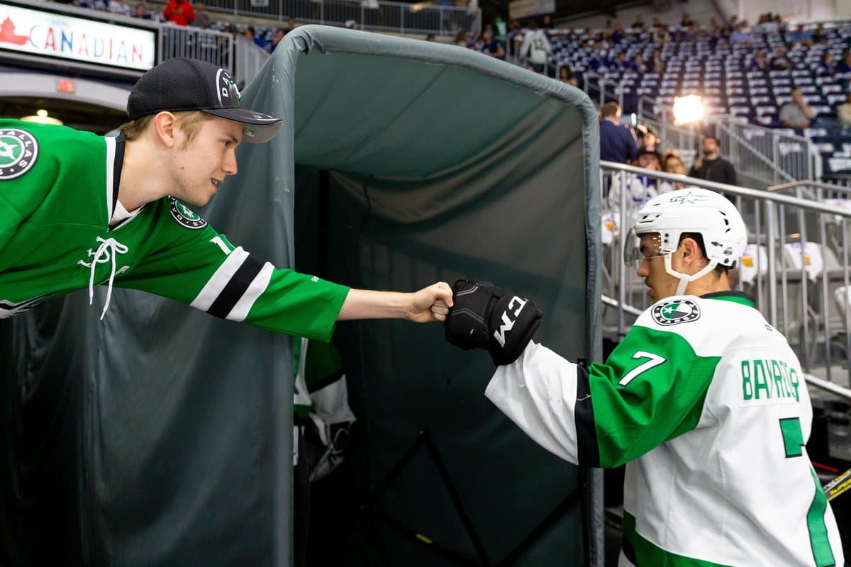 Gavin Bayreuther fist-bumping a young fan on his way to the ice