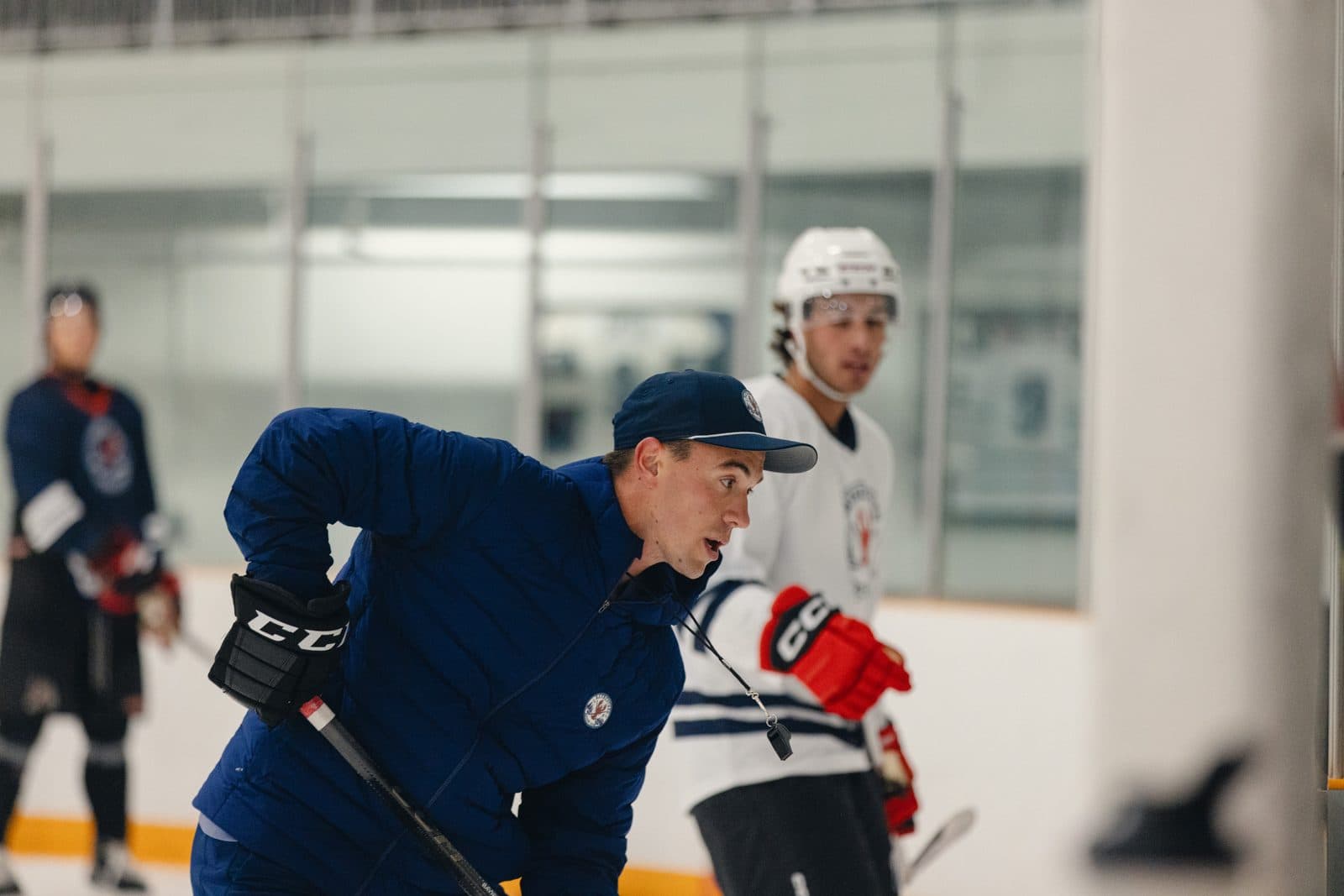 Gavin Bayreuther coaching a player on the ice at a BHC camp