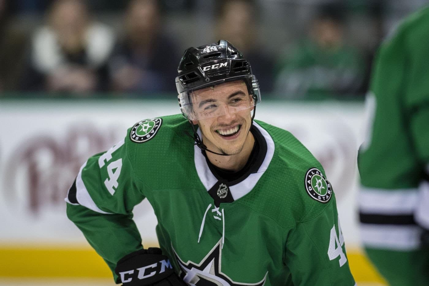 Gavin Bayreuther smiling on the ice in a Dallas Stars jersey
