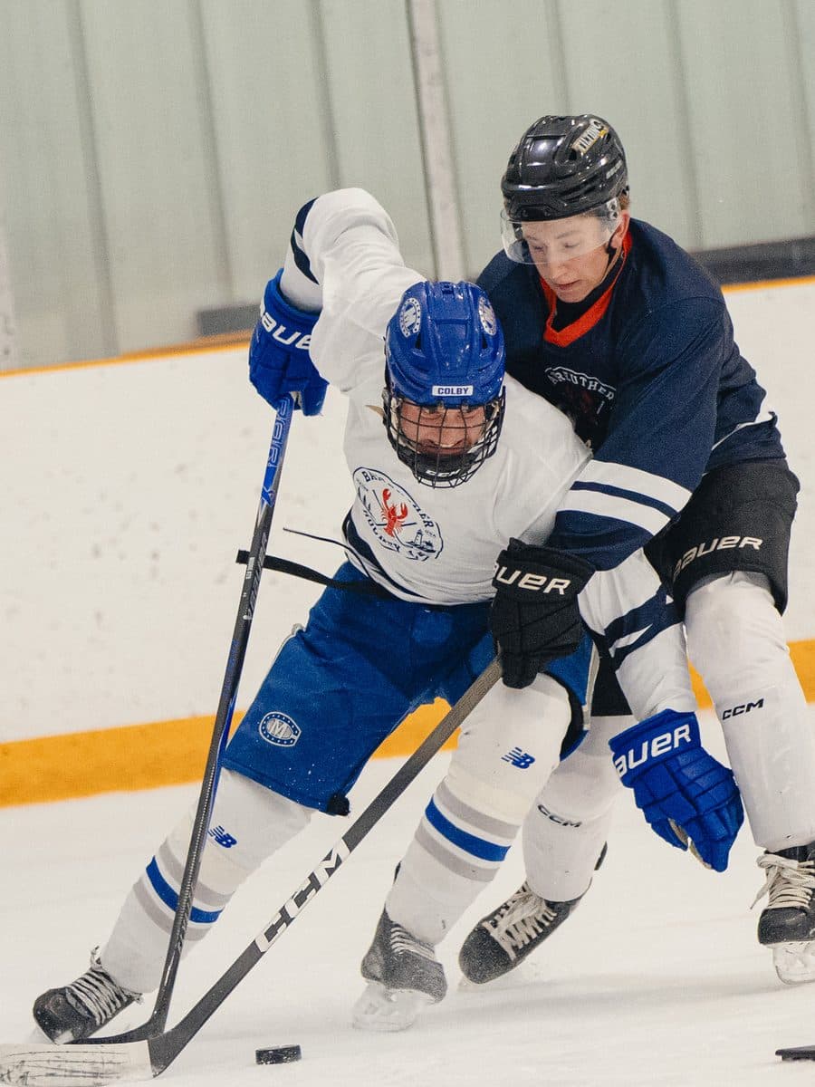Two players competing for the puck at a BHC camp